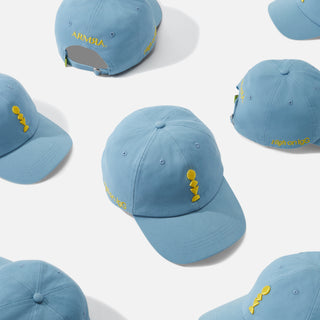 Several Blue Baseball Caps with a Yellow Embroidered Design on a White Background