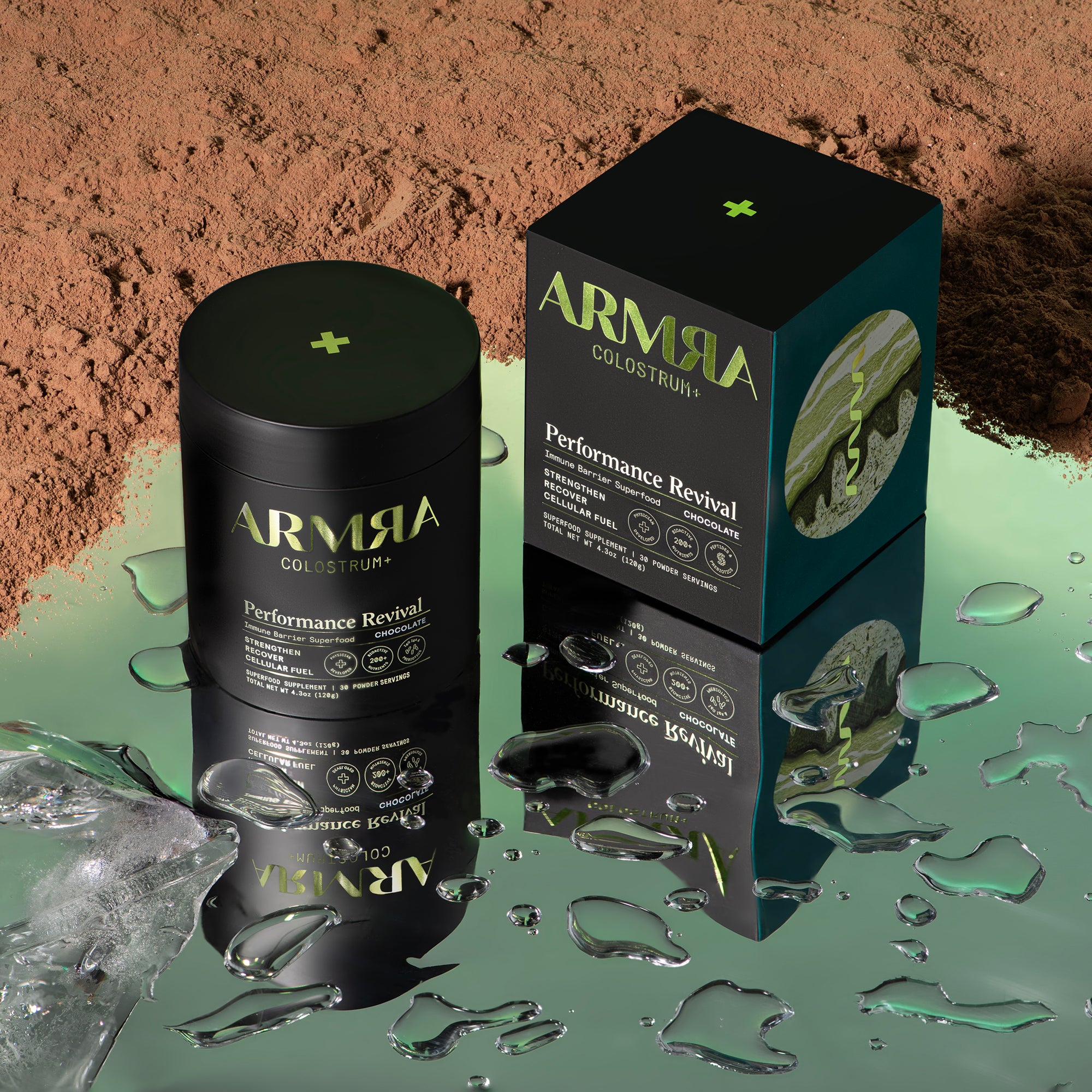 Jar of ARMRA Colostrum™ Performance Revival and Performance Revival Packaging on a mirrored surface with chocolate colostrum powder.