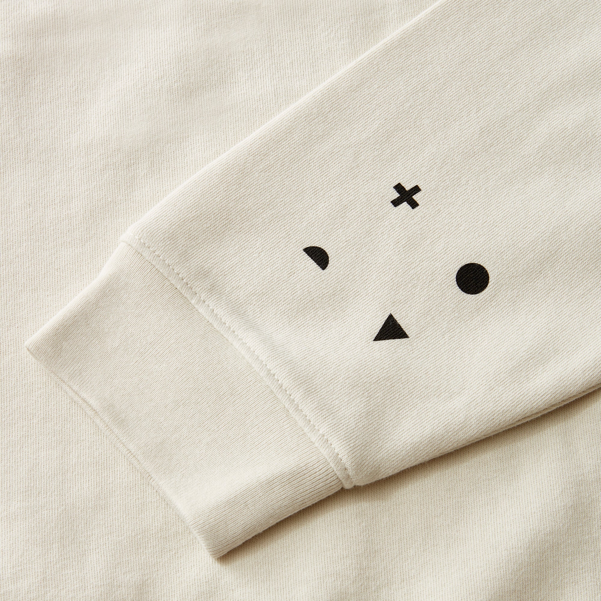 Sleeve of a Cream Sweatshirt with black icon design
