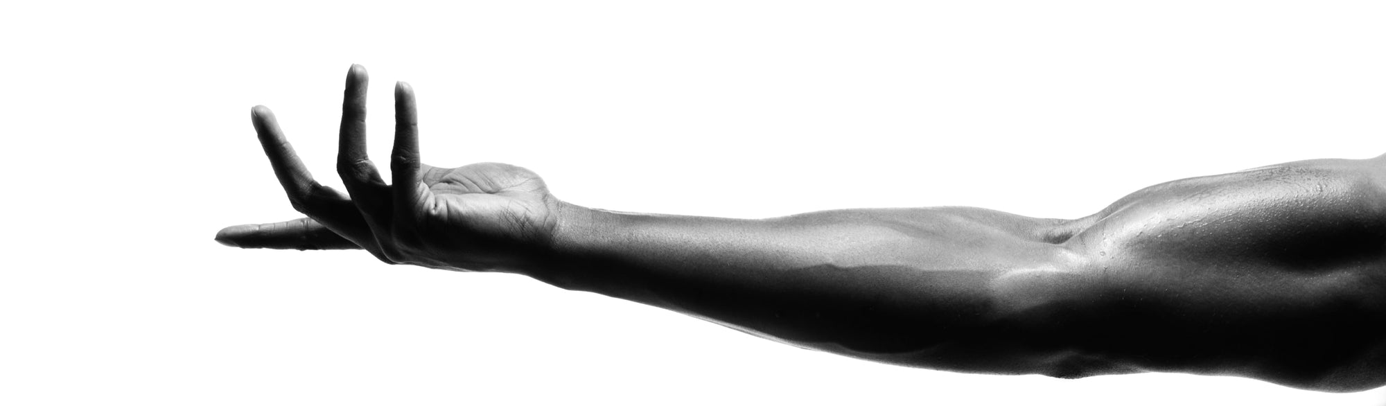 black and white photo with arm extended and stretched out with palm facing up and fingers flexed slightly on a white background
